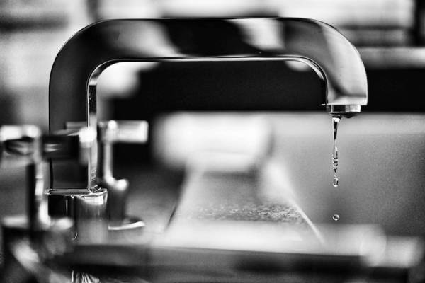 Silver bathroom faucet dripping water