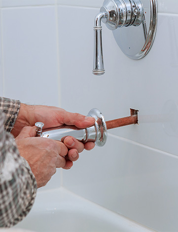 a plumber installing a bathtub faucet