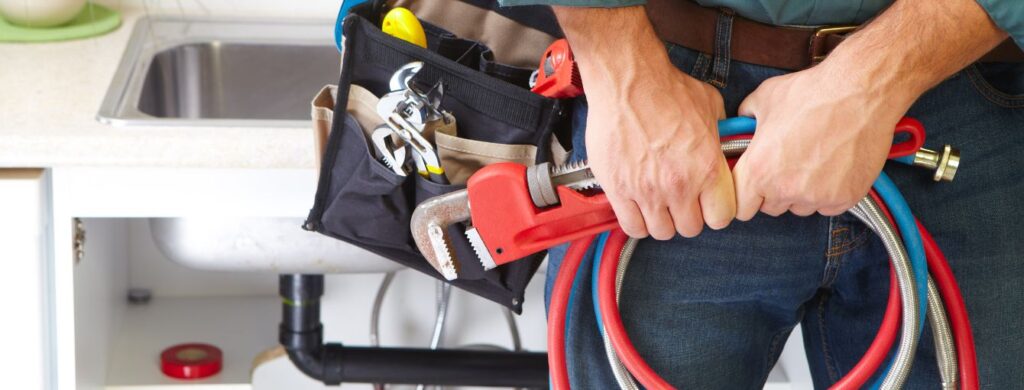 A plumber holding tools of the trade.