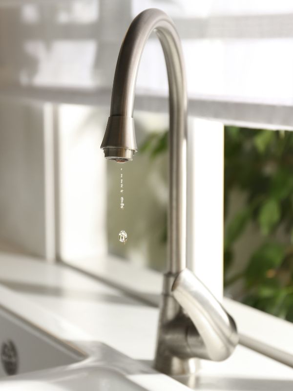 A leaking faucet in a residential kitchen. 