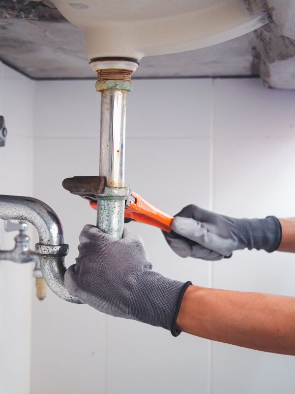 A plumber fixing a stubborn clog in a sink. 
